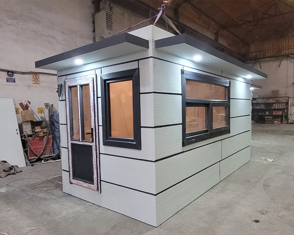 Beyaz-antrasit kombinasyonlu Metropol Kabin, PVC kapı ve pencereler koruyucu filmle fabrika içinde